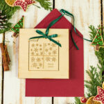 Kreatywne i eleganckie biznesowe kartki świąteczne z logo firmy – bożonarodzeniowe życzenia z drewnianą zawieszką i delikatną wstążką