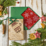 Kartki świąteczne dla firm z logo: Drewniana bombka zawieszka na choinkę i świateczna kartka firmowa z rękawicą.