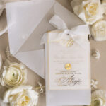 Złote zaproszenia na Pierwszą Komunię w eleganckiej kieszonce z wstążką